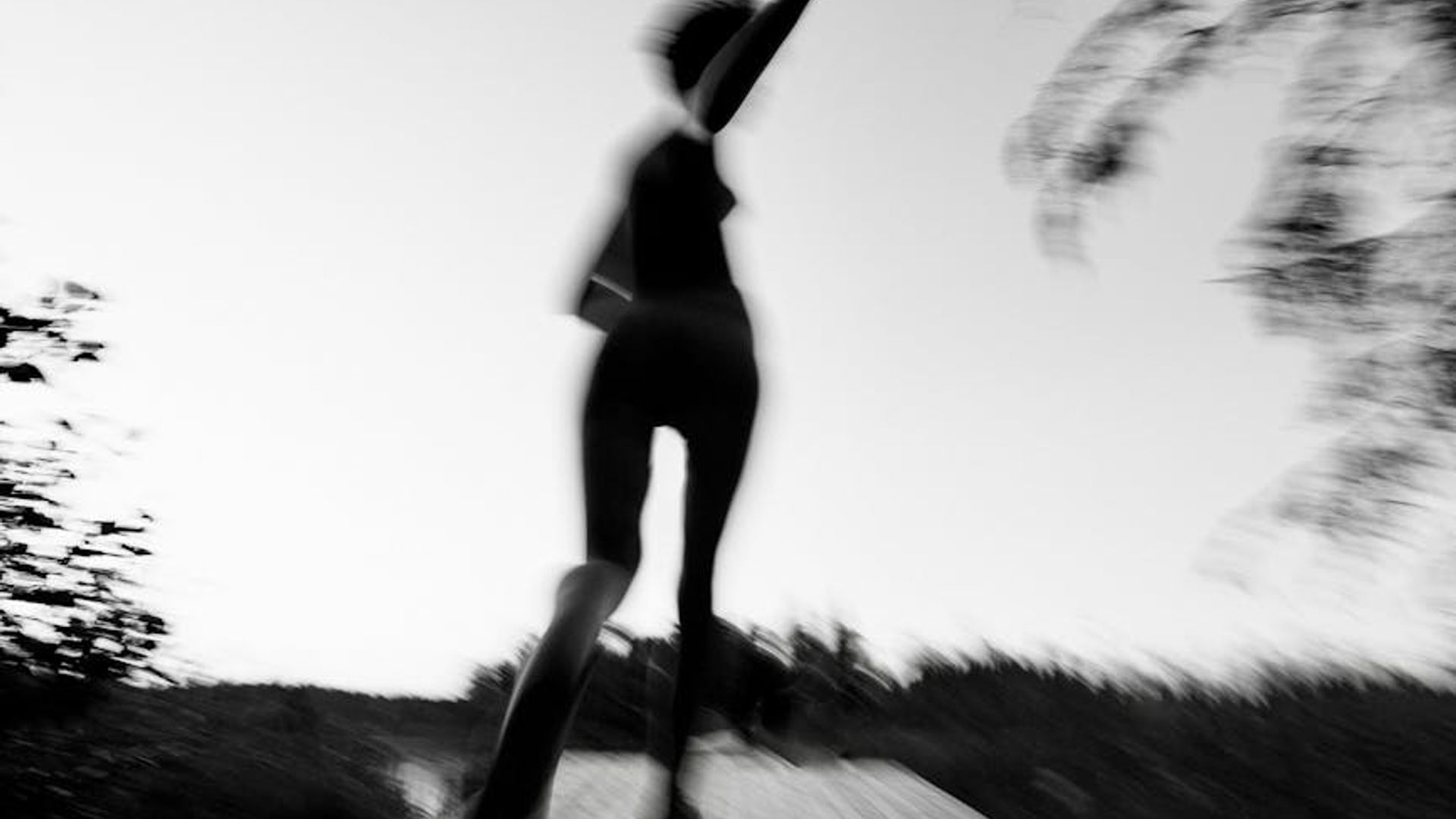 Abstract silhouette of a person in motion with soft light trails.