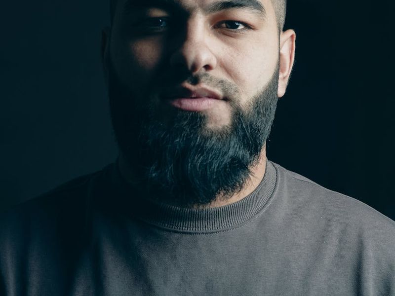Man in a dynamic cardio pose against a dark background.